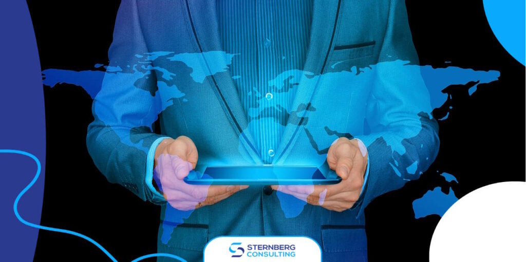 man in suit holding tablet projecting world map